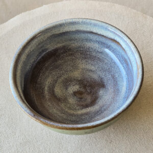 A small bowl made of terra red ceramic. Glazed a subtle blue opal inside and copper green outside. .Ceramic fired to cone 6 oxidation