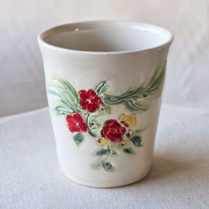 Porcelain cup with hand painted floral design.