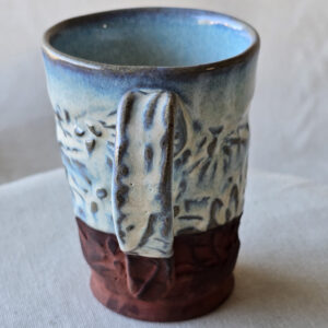 A beautiful opalescent colored mug with hints of blue floating through.